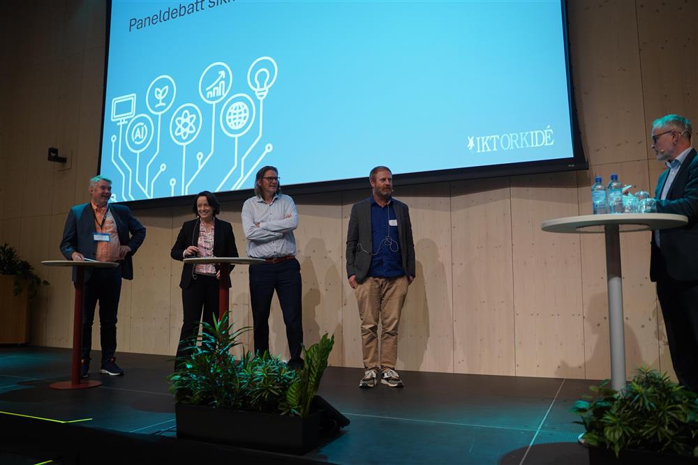 Fire personer står i debatt med en til som leder debatten - Klikk for stort bilde