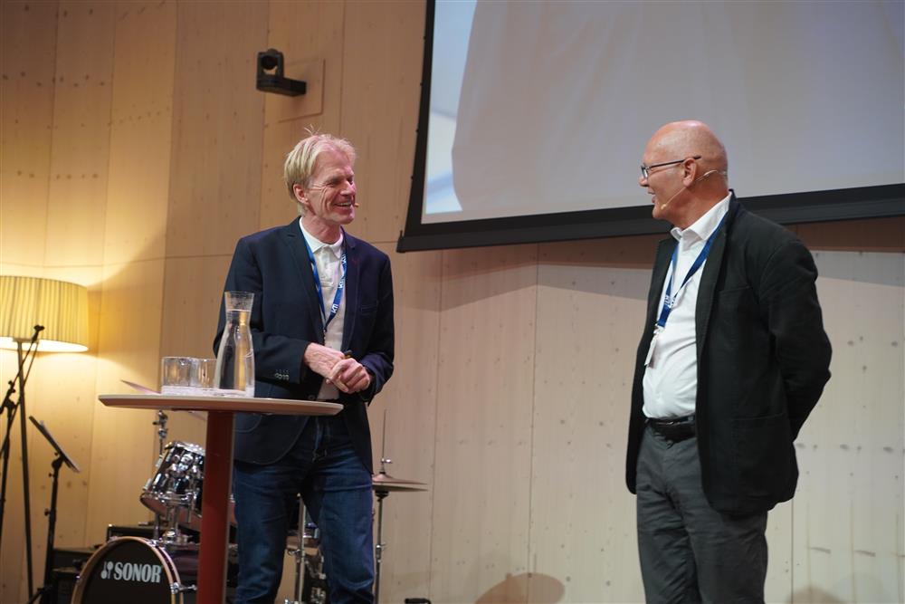 Geir Vinsand og Håvard Moe diskuterer fremtiden til kommunene forran salen - Klikk for stort bilde
