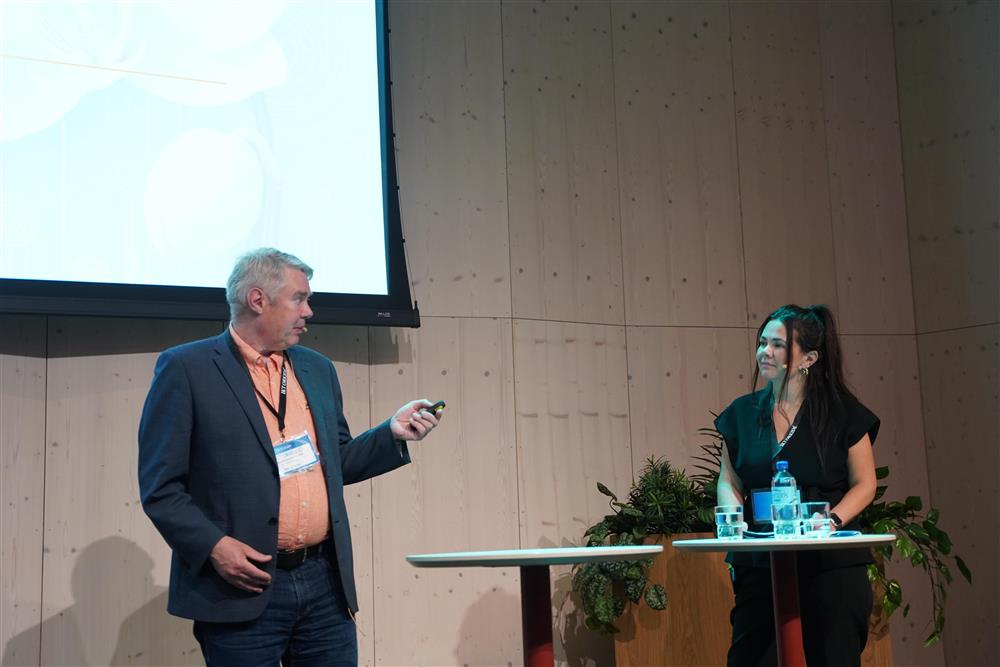 To personer snakker sammen på scenen - Klikk for stort bilde